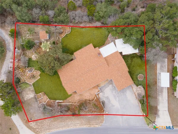 an aerial view of a house with a yard and lake view
