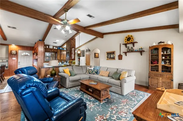 a living room with furniture a wooden floor and next to a window