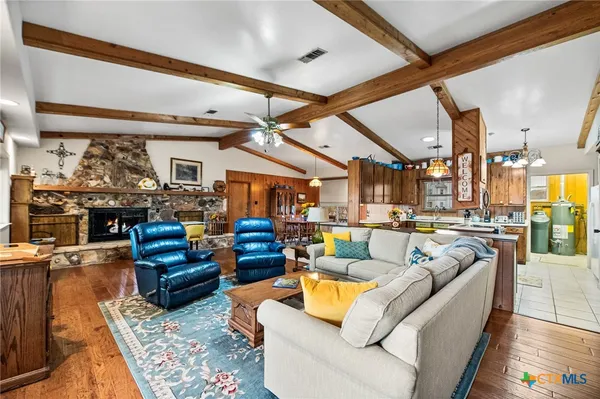 a living room with furniture kitchen view and a large window