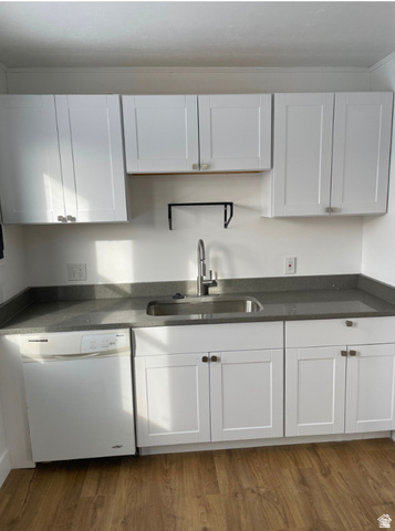 230 North 2nd Street Tooele, UT 84074 - Photo 3 of 18 Kitchen featuring white shaker-style cabinetry, dark speckled countertops, a stainless steel sink with a gooseneck faucet, a white dishwasher, and wood-finish flooring