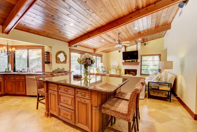 a dining hall with stainless steel appliances granite countertop a sink and cabinets