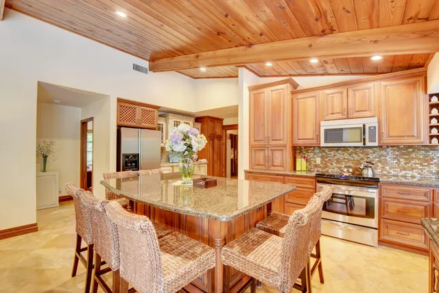 a dining table with chairs and kitchen view