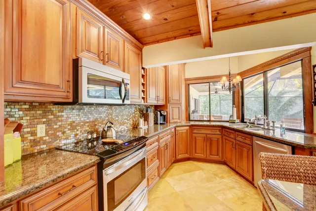 a kitchen with stainless steel appliances granite countertop a sink and cabinets