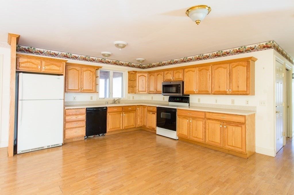 76 Davis Road New Braintree, MA 01531 - Photo 3 of 40 a large kitchen with stainless steel appliances granite countertop a stove a sink dishwasher a microwave oven and a refrigerator with wooden floor