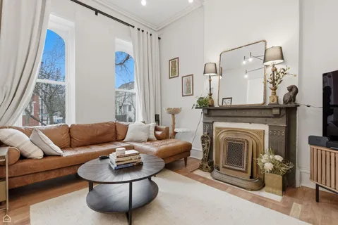 a living room with furniture a fireplace and a chandelier