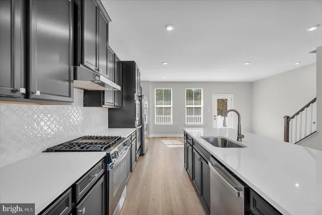 a kitchen with stainless steel appliances a sink stove and cabinets
