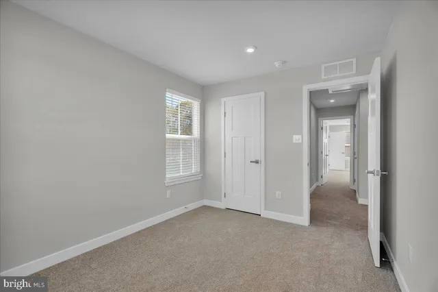 an empty room with windows and closet