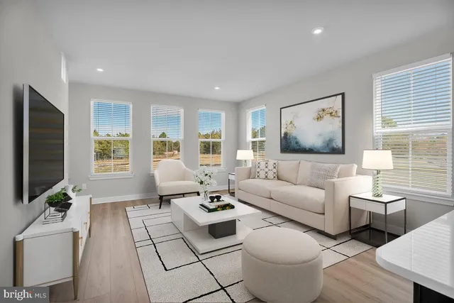 a living room with furniture a flat screen tv and a window