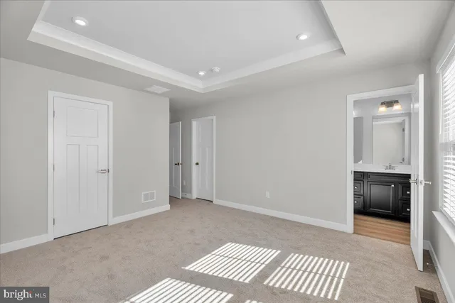 a view of an empty room with kitchen and a window
