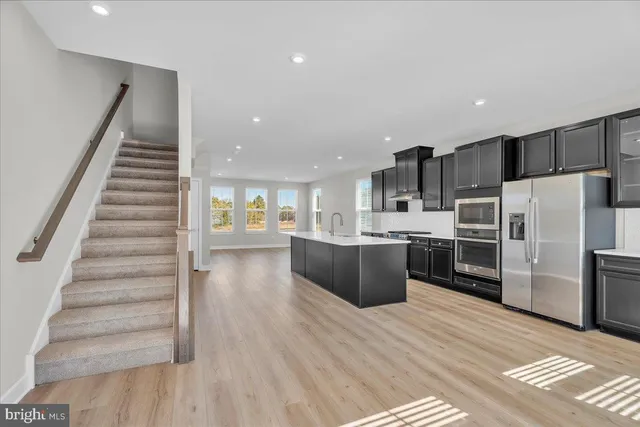a kitchen with stainless steel appliances a refrigerator and a stove top oven