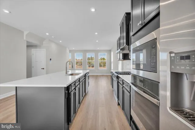 a kitchen with stainless steel appliances granite countertop a sink and stove