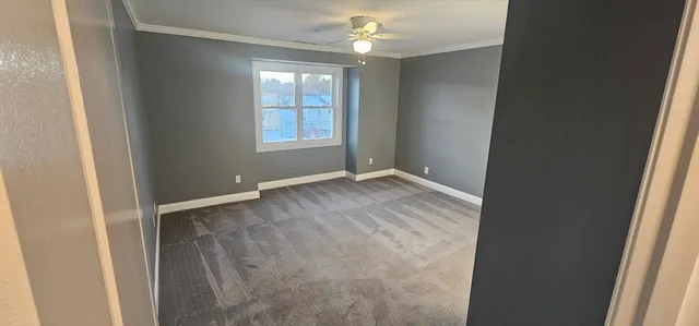 an empty room with windows and chandelier