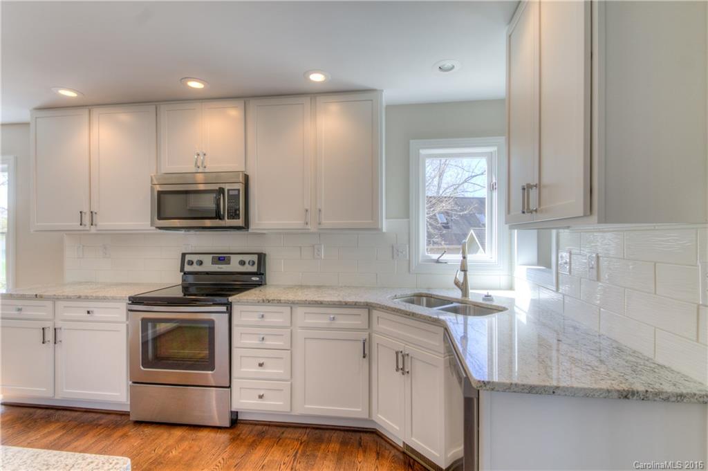 9827 Withers Road Charlotte, NC 28278 - Photo 7 of 24 a kitchen with stainless steel appliances granite countertop a sink a stove and a microwave