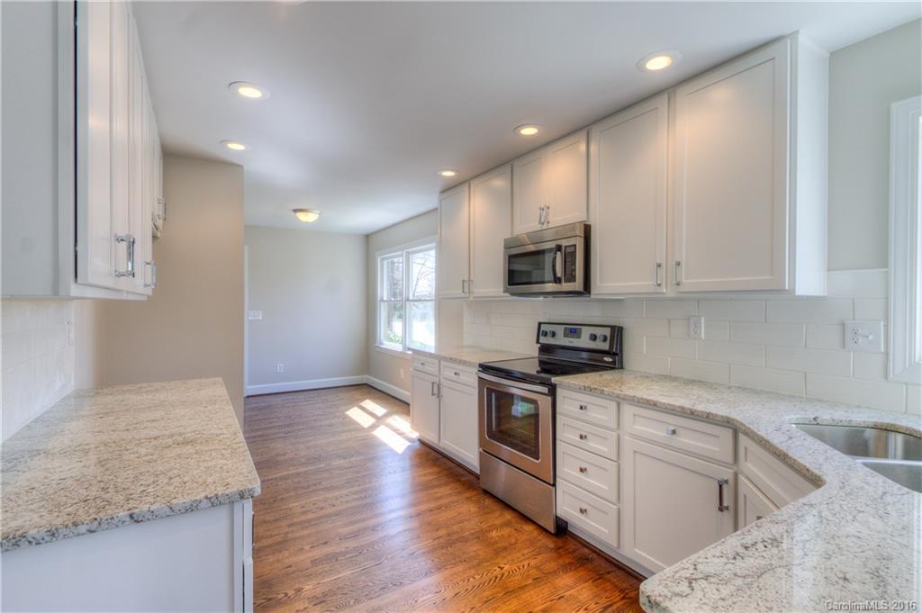 9827 Withers Road Charlotte, NC 28278 - Photo 8 of 24 a kitchen with granite countertop white cabinets and stainless steel appliances
