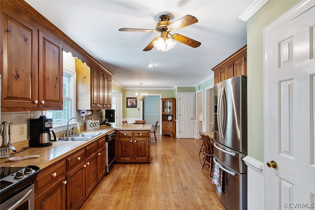 6611 Glebe Point Road Chesterfield, VA 23838 - Photo 15 of 44 a large kitchen with stainless steel appliances a stove a refrigerator a sink dishwasher a dining table and chairs with wooden floor