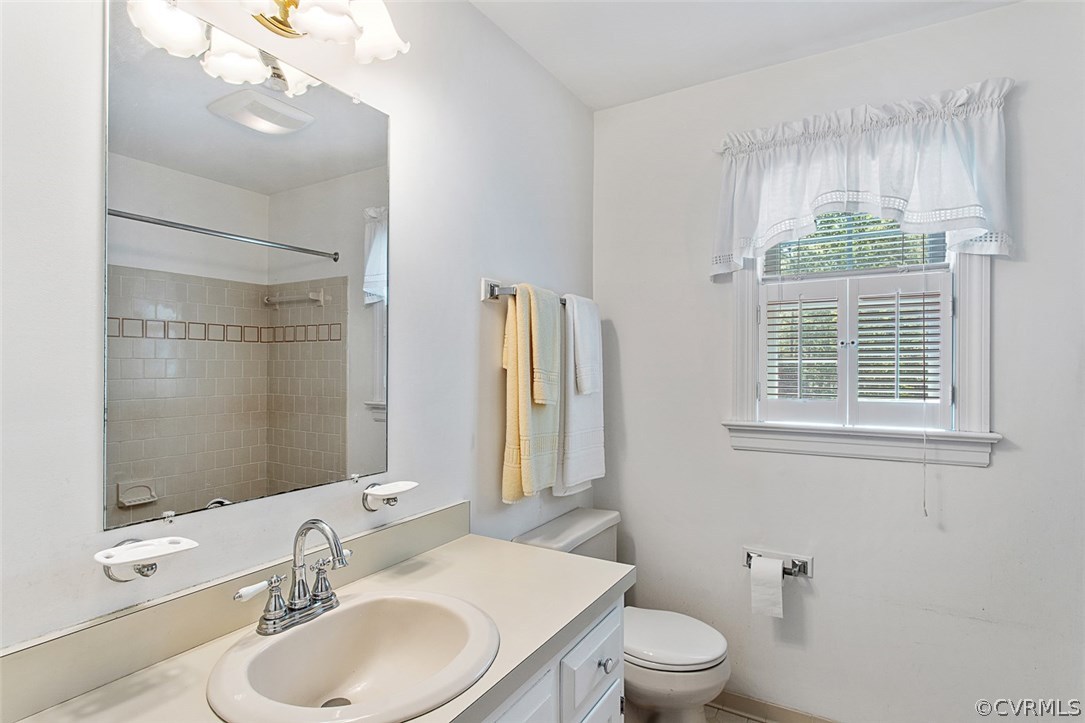 6611 Glebe Point Road Chesterfield, VA 23838 - Photo 24 of 44 a bathroom with a toilet a sink a mirror a window and vanity