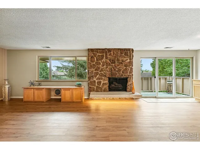 a view of empty room with wooden floor and fireplace