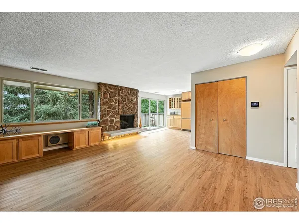 a view of empty room with wooden floor and fireplace