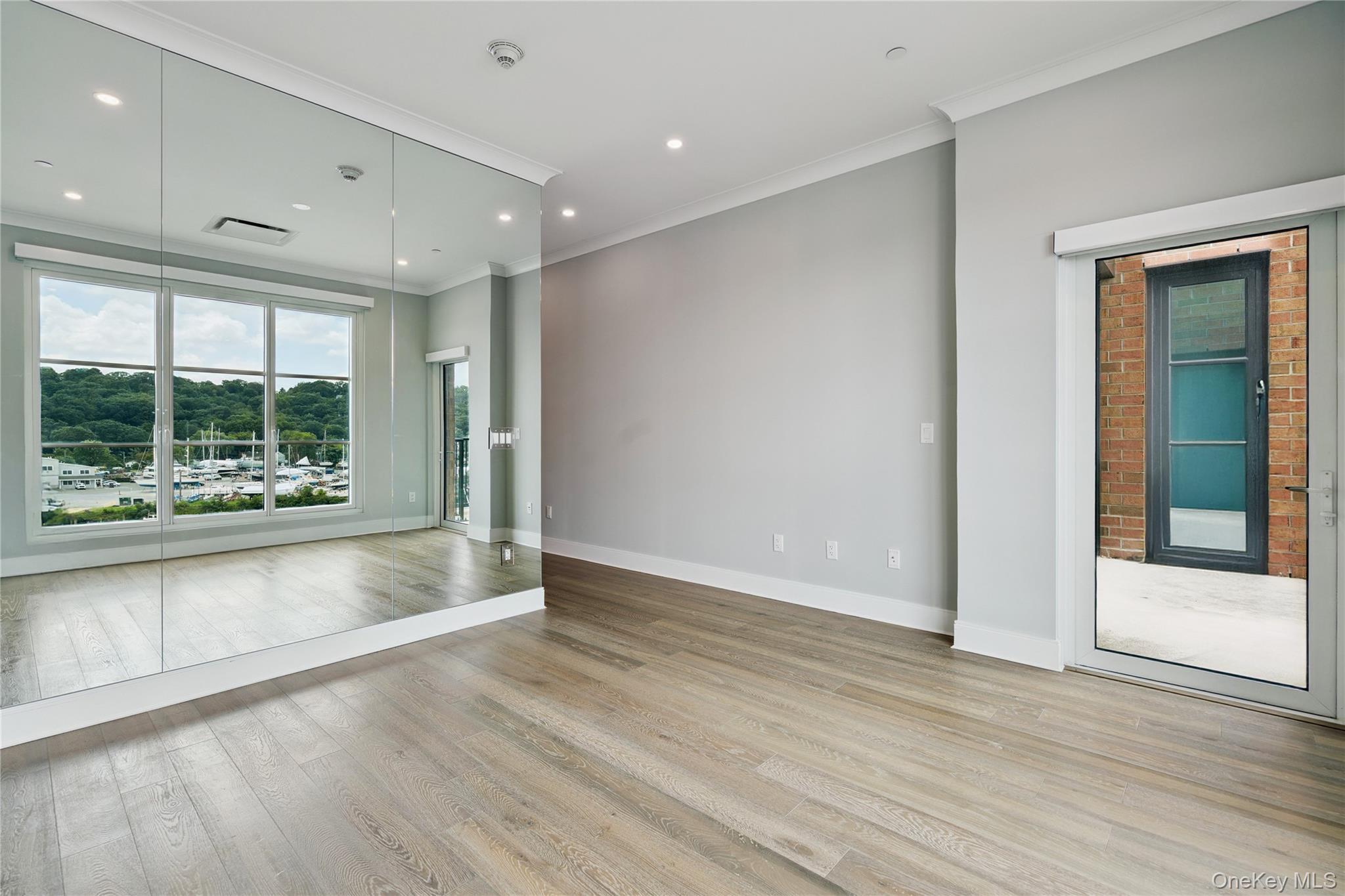 100 Garvies Point Road, Unit 1304 Glen Cove, NY 11542 - Photo 12 of 34 Primary bedroom with crown molding, wood finished floors, and recessed lighting
