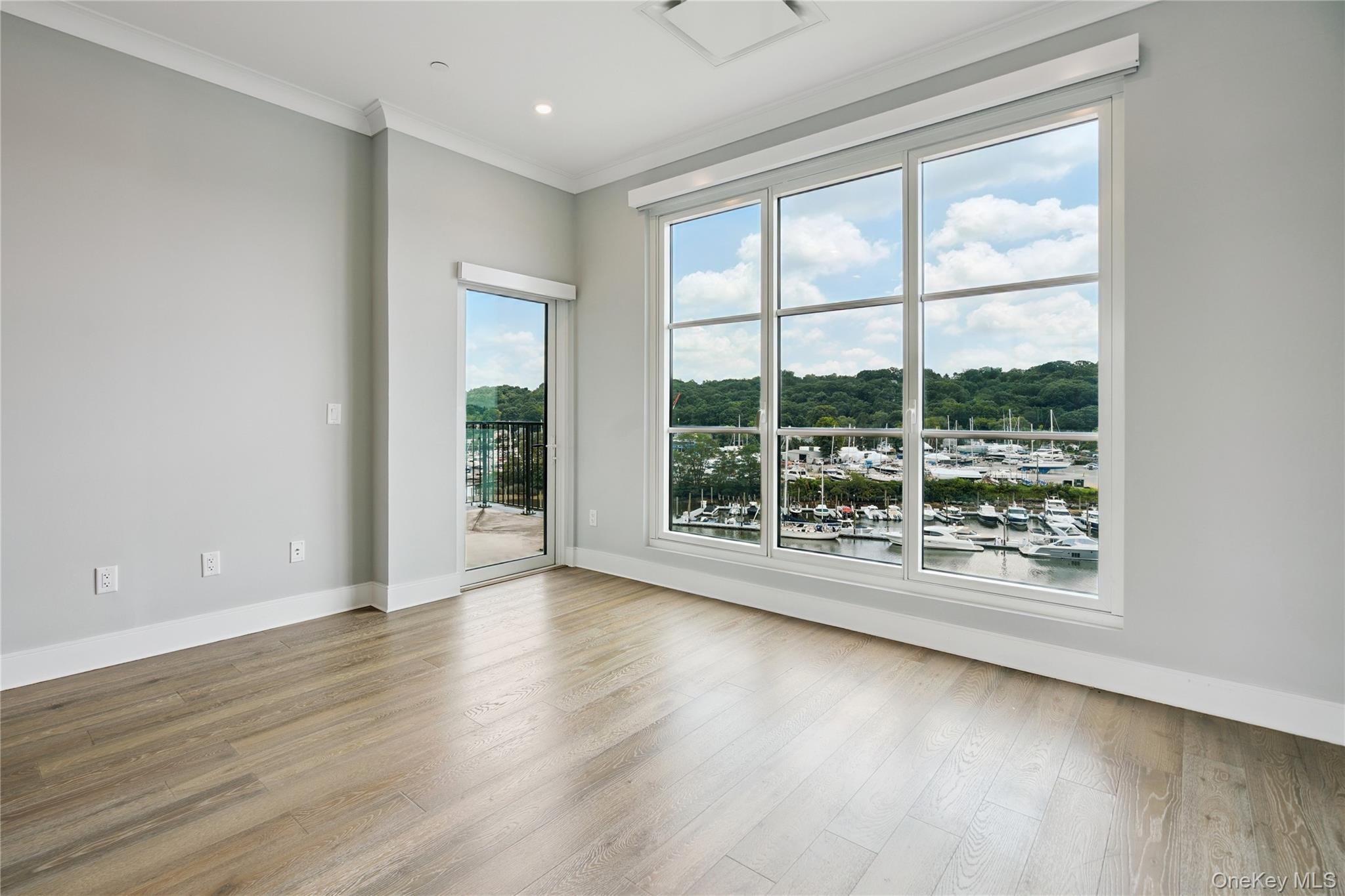 100 Garvies Point Road, Unit 1304 Glen Cove, NY 11542 - Photo 13 of 34 Primary bedroom with crown molding, wood finished floors, and access to balcony