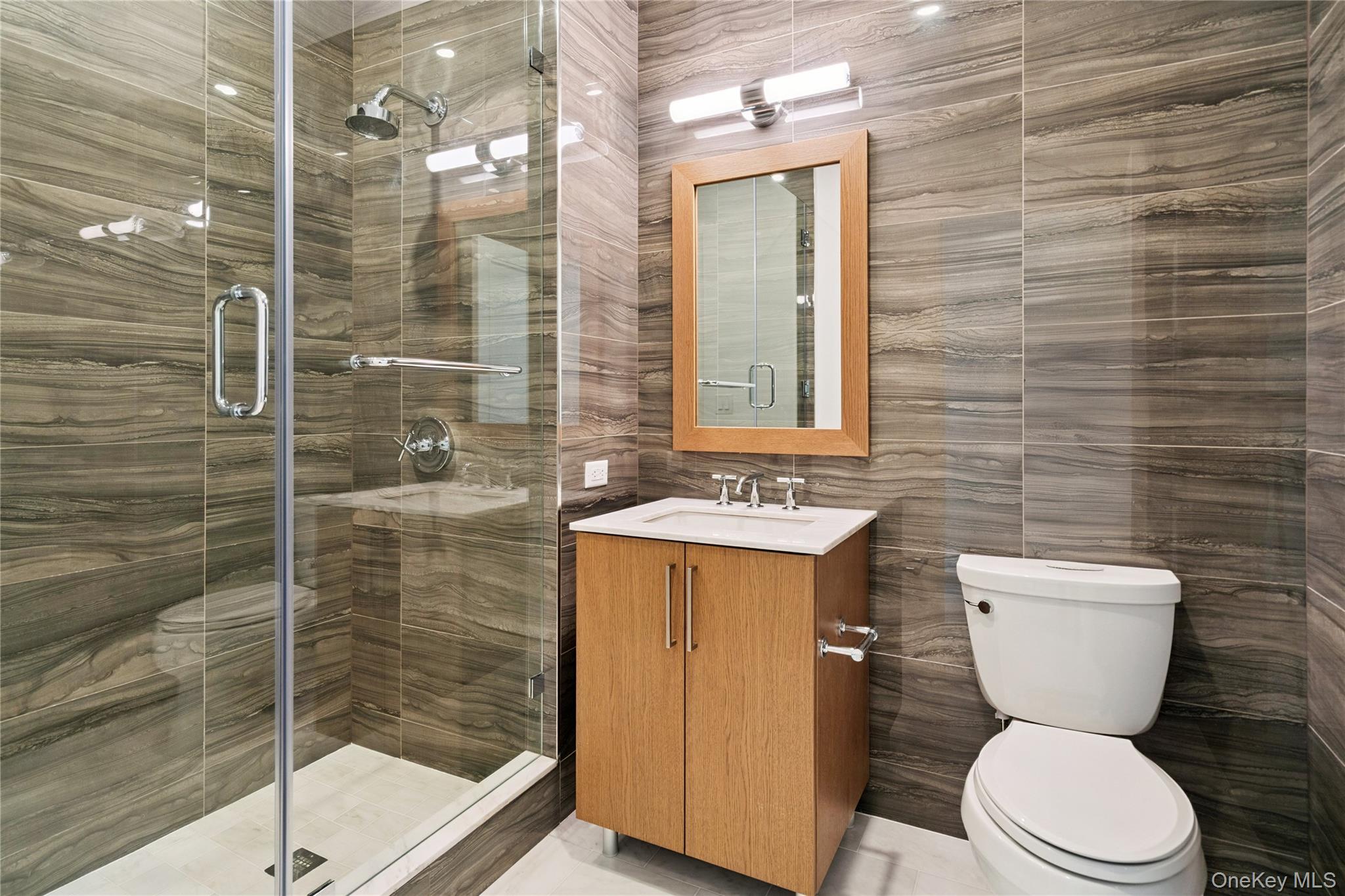 100 Garvies Point Road, Unit 1304 Glen Cove, NY 11542 - Photo 18 of 34 Bathroom with tile walls, vanity, and a shower
