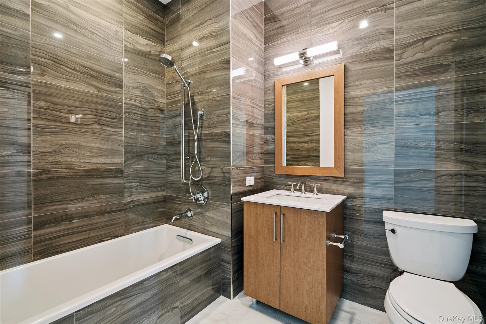 100 Garvies Point Road, Unit 1304 Glen Cove, NY 11542 - Photo 20 of 34 Full bath featuring tiled shower / bath, vanity, and tile walls