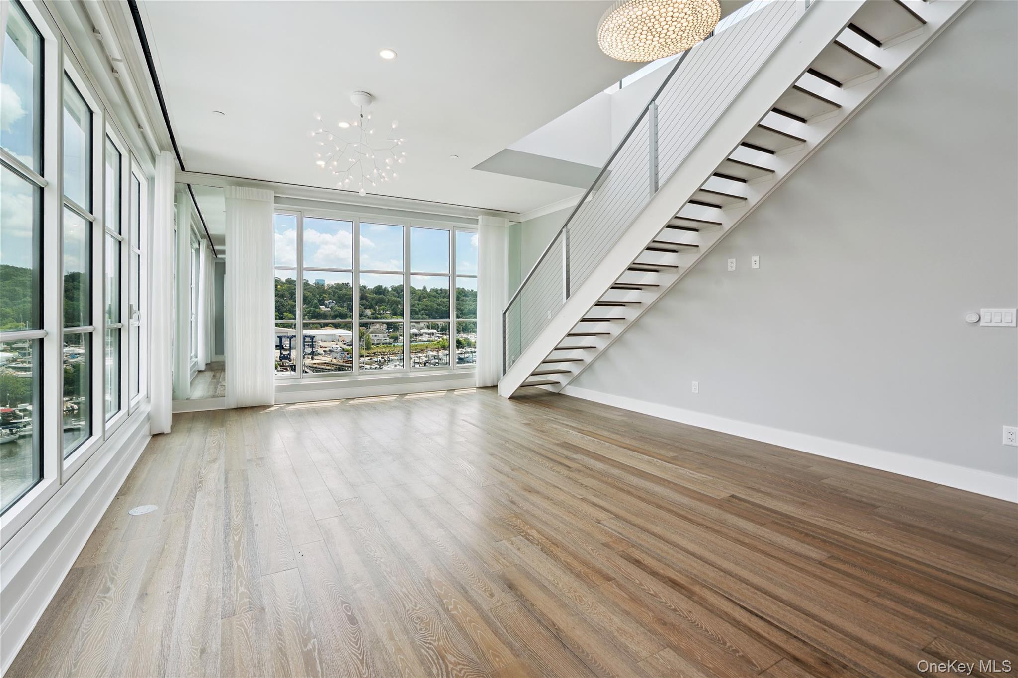 100 Garvies Point Road, Unit 1304 Glen Cove, NY 11542 - Photo 7 of 34 Living room featuring stairway to rooftop terrace