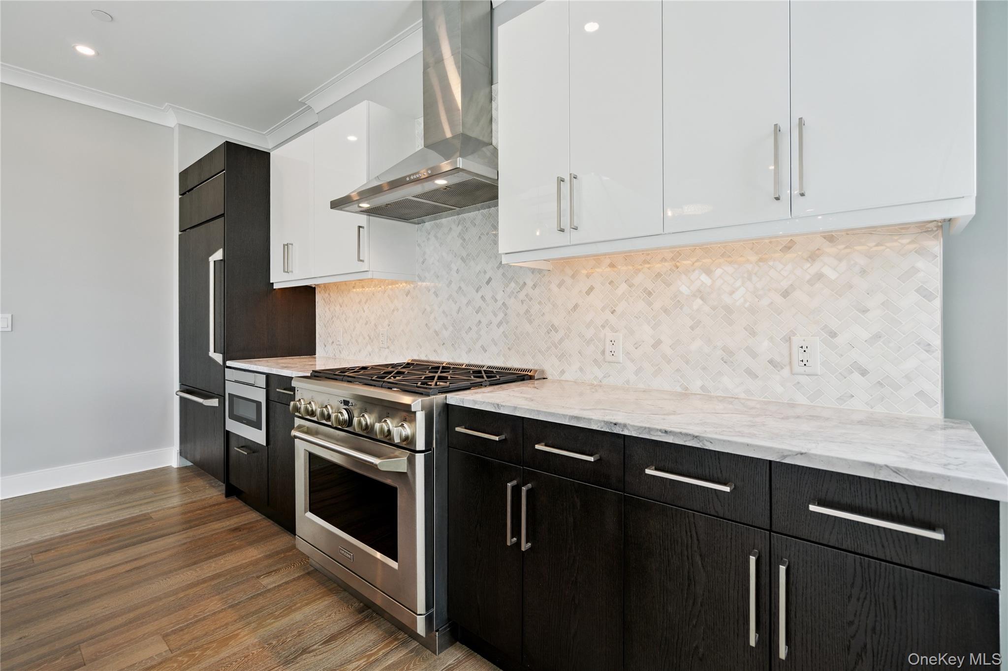 100 Garvies Point Road, Unit 1304 Glen Cove, NY 11542 - Photo 9 of 34 Kitchen featuring range hood, high end appliances, white and dark cabinets