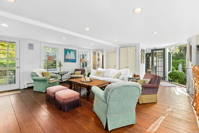 a living room with furniture a lamp wooden floor and a large window