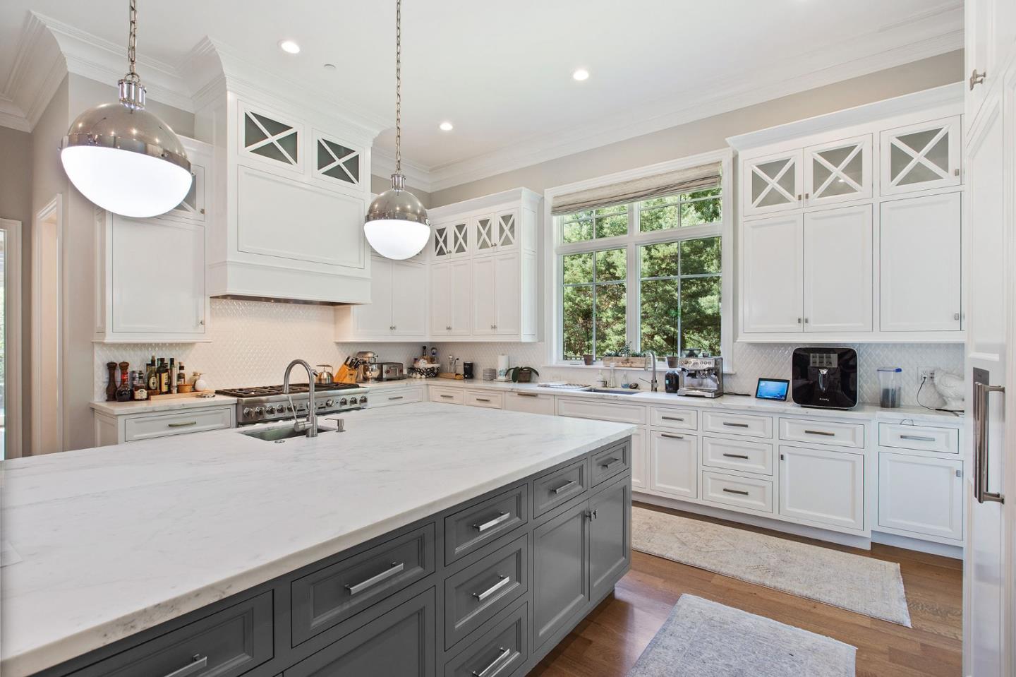 250 Bridge Road Hillsborough, CA 94010 - Photo 19 of 80 a kitchen with a sink cabinets a window and a chandelier