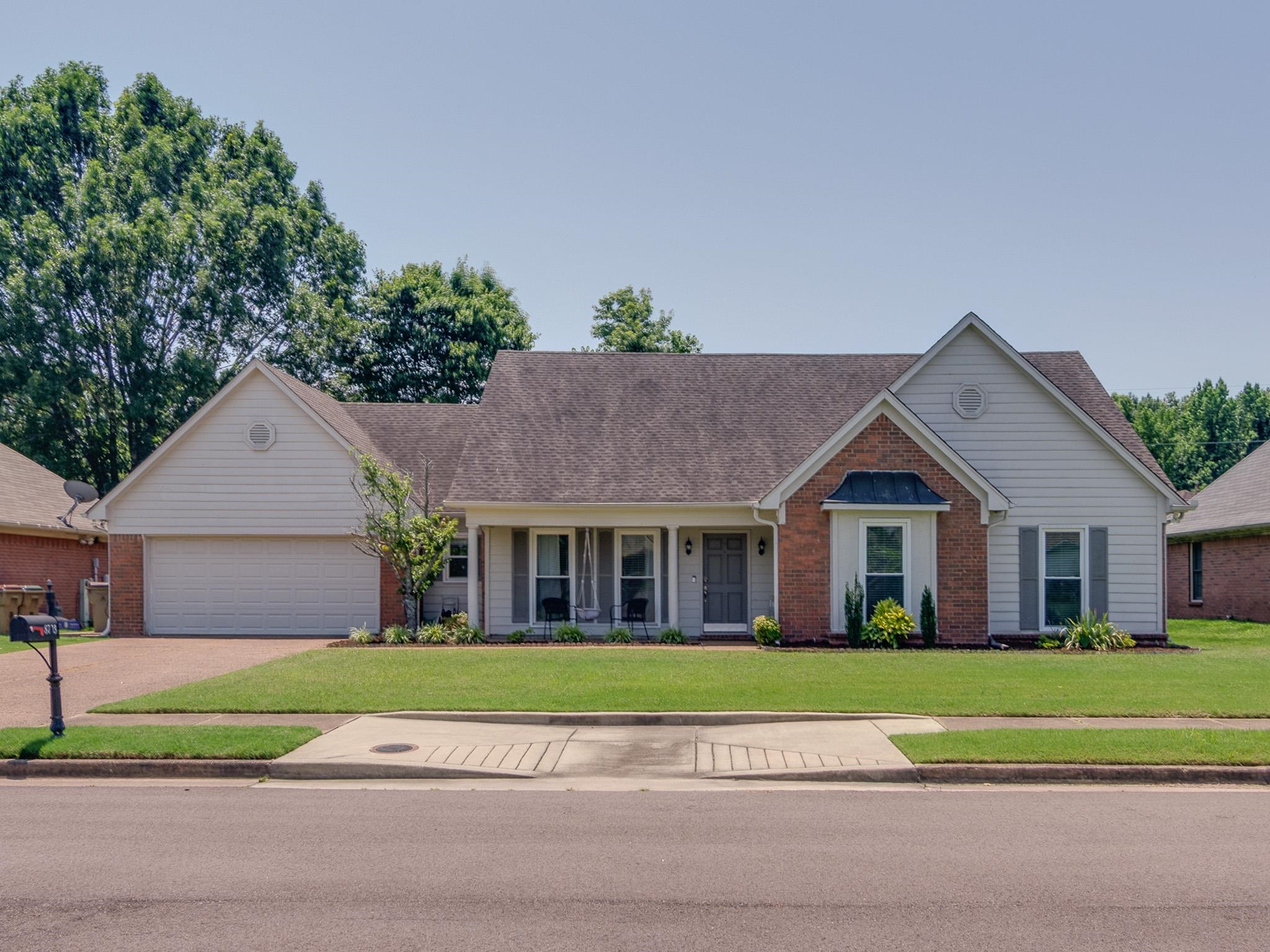 8703 Old River Road Memphis, TN 38018 - Photo 1 of 31 Ranch-style house featuring a front yard, brick siding, a garage, driveway, and a shingled roof