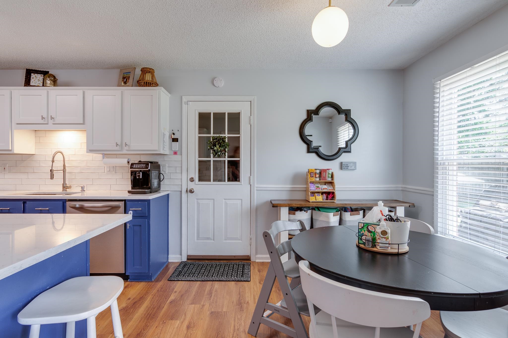 8703 Old River Road Memphis, TN 38018 - Photo 15 of 31 Kitchen with blue cabinetry, dishwasher, light countertops, light wood-style floors, and a textured ceiling