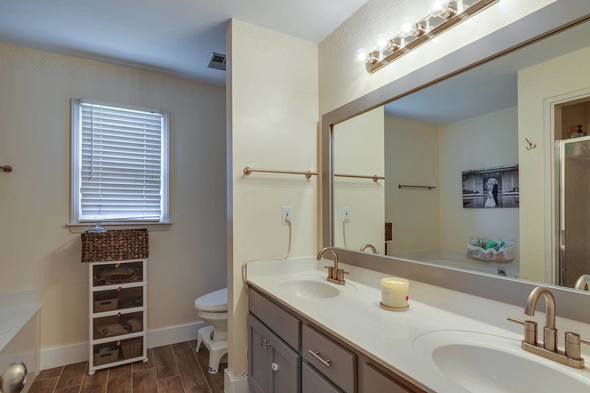 8703 Old River Road Memphis, TN 38018 - Photo 19 of 31 Bathroom with double vanity, wood finish floors, a shower with shower door, and a bath