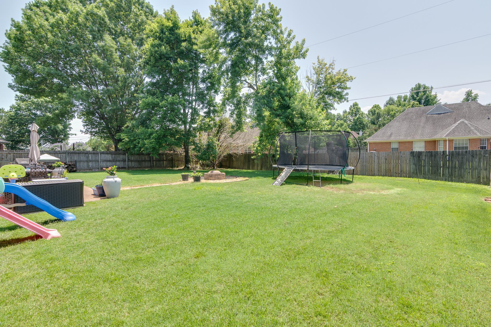 8703 Old River Road Memphis, TN 38018 - Photo 30 of 31 Fenced backyard with a trampoline and a fire pit