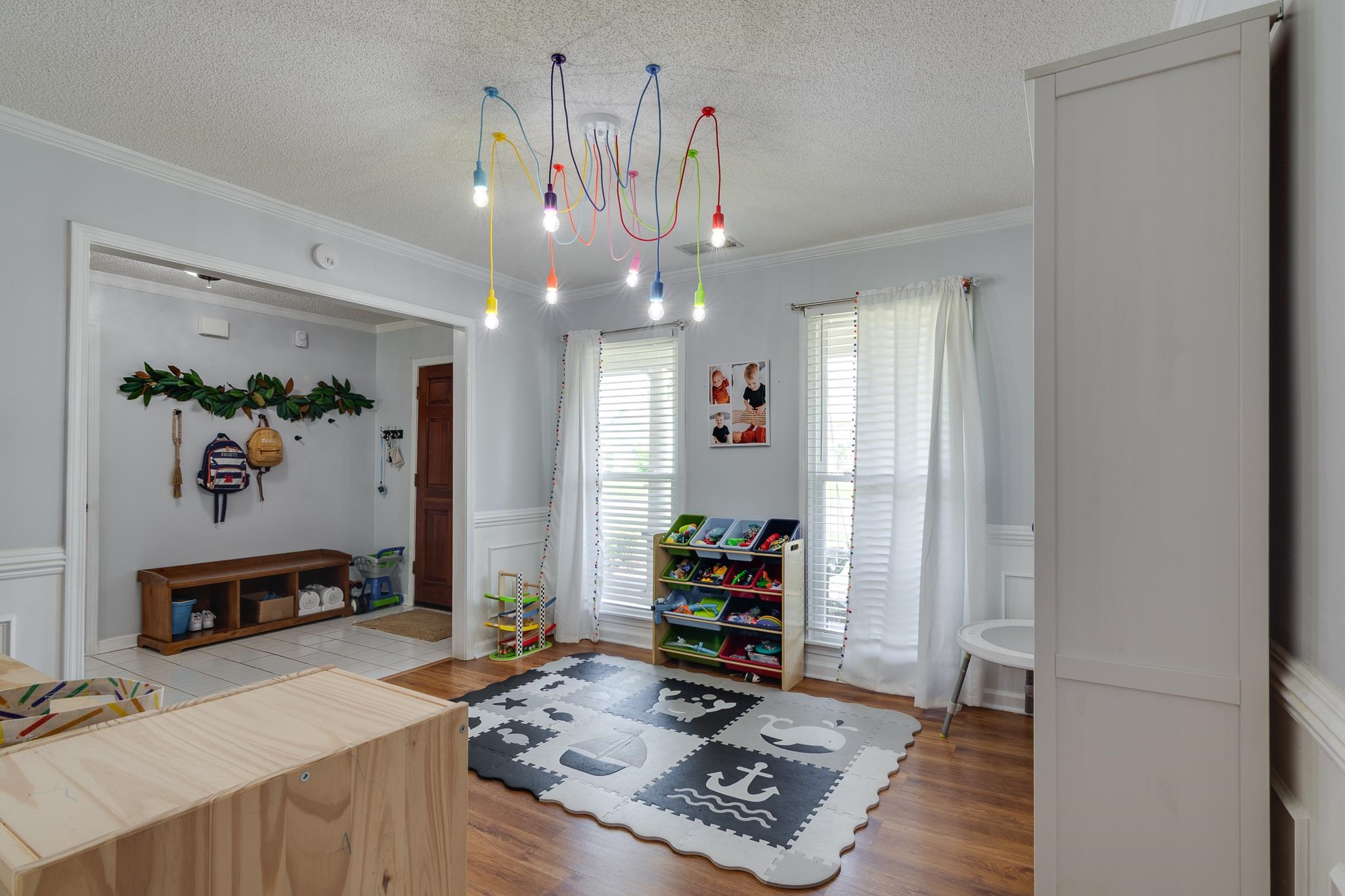 8703 Old River Road Memphis, TN 38018 - Photo 3 of 31 Dining room featuring a textured ceiling, a wainscoted wall, crown molding, wood finished floors, and a decorative wall