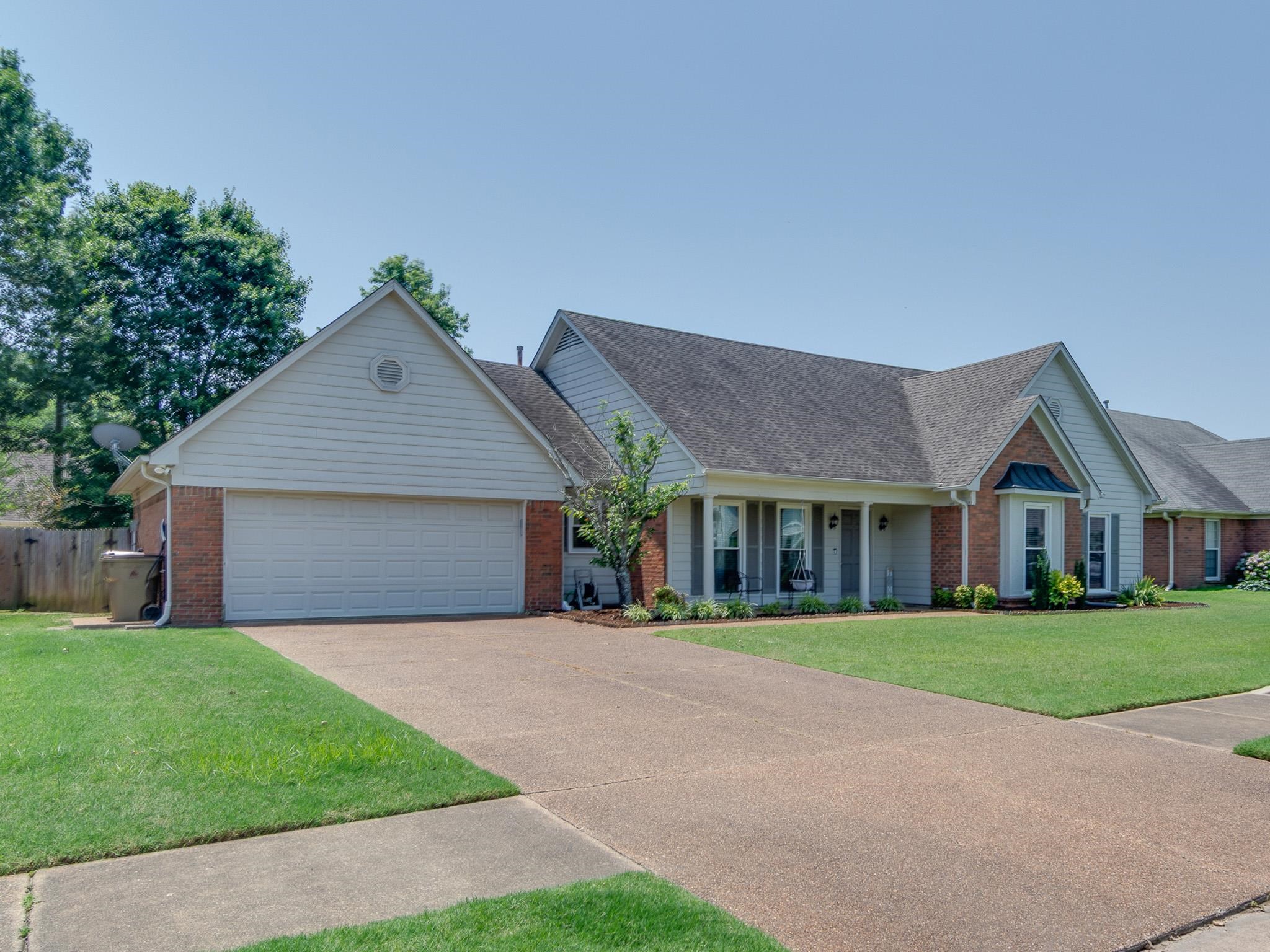 8703 Old River Road Memphis, TN 38018 - Photo 31 of 31 View of front facade featuring brick siding, driveway, a garage, roof with shingles, and covered porch