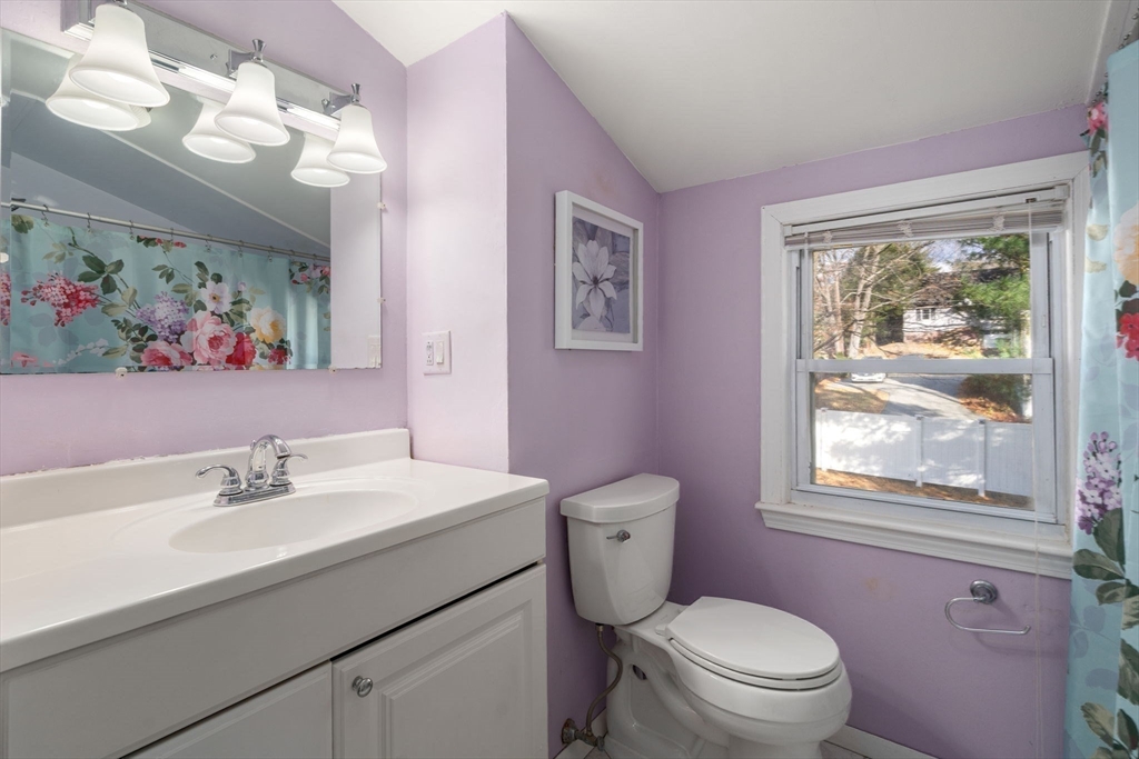 102 Montgomery Avenue Lowell, MA 01851 - Photo 20 of 40 a bathroom with a toilet a sink a mirror and a window