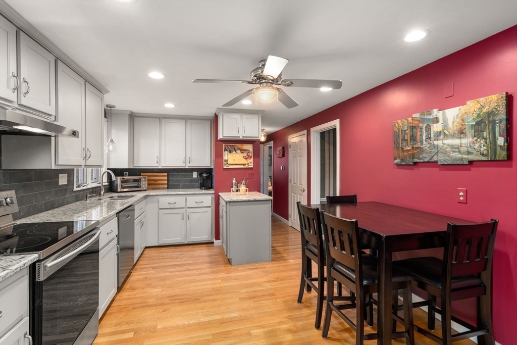 102 Montgomery Avenue Lowell, MA 01851 - Photo 9 of 40 a kitchen with a table chairs microwave and cabinets