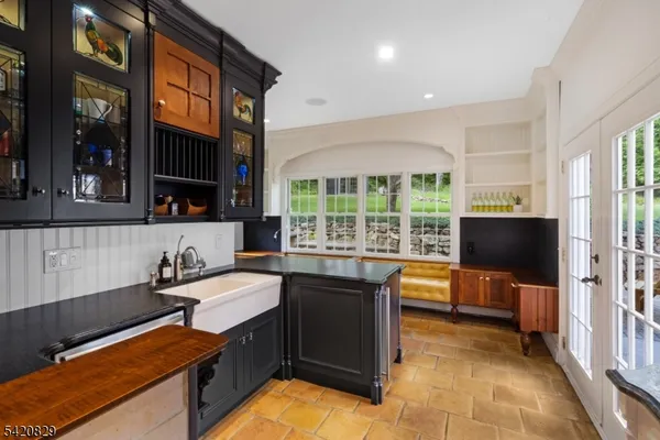 a kitchen with stainless steel appliances granite countertop a stove top oven a sink dishwasher and chairs with wooden floor