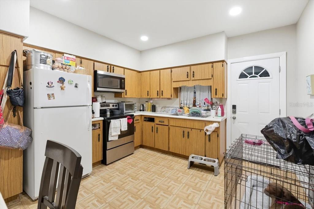 2511 West Abdella Street Tampa, FL 33607 - Photo 10 of 17 a kitchen with granite countertop a refrigerator a sink and white appliances