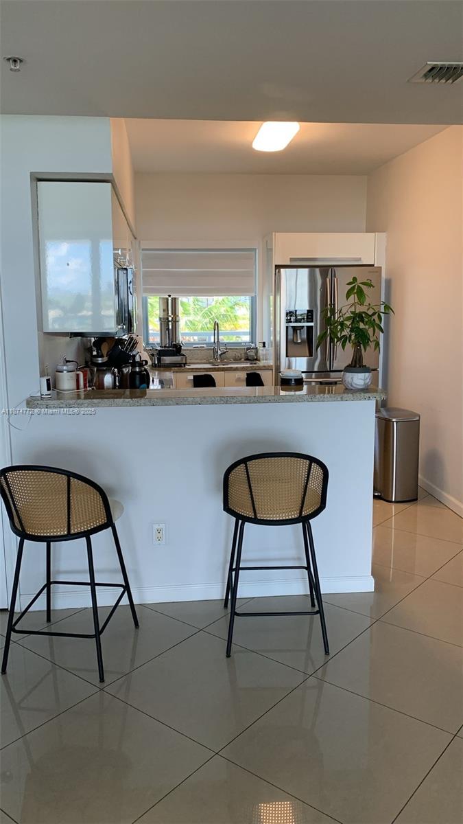 601 Northeast 36th Street, Unit 806 Miami, FL 33137 - Photo 21 of 28 a living room with chairs a rug and a painting on the wall