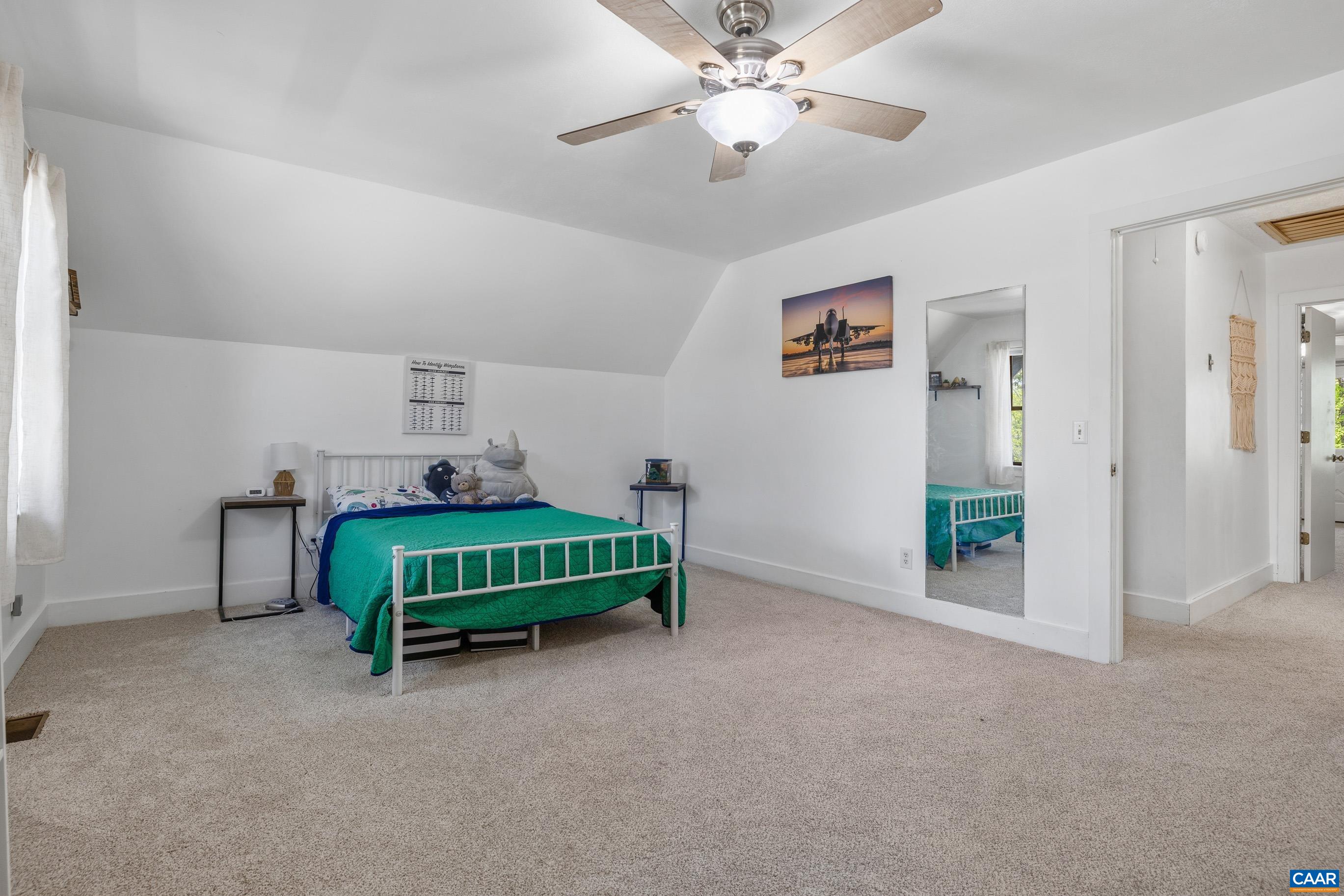 2947 Merrie Meadows Lane Keswick, VA 22947 - Photo 51 of 75 a spacious bedroom with a bed and a chandelier