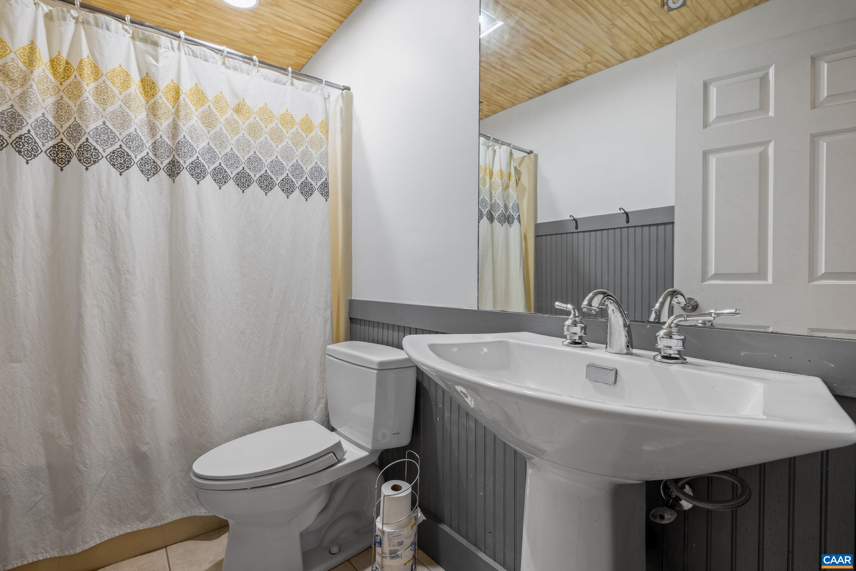 2947 Merrie Meadows Lane Keswick, VA 22947 - Photo 62 of 75 a bathroom with a sink a toilet and shower curtain