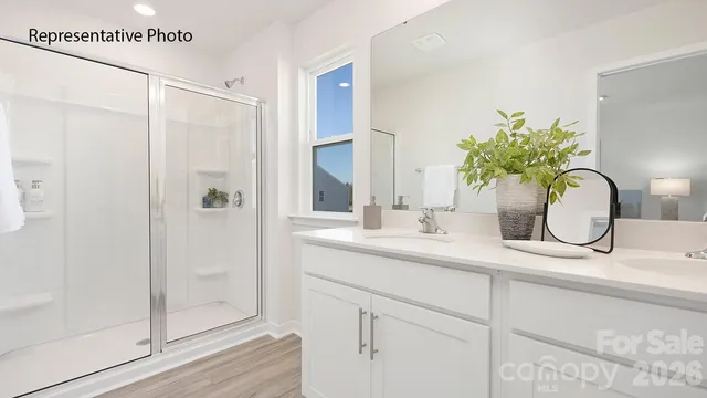 a bathroom with a granite countertop sink a mirror and shower