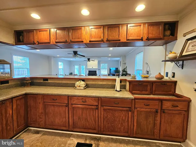 a kitchen with kitchen island granite countertop wooden cabinets and a sink