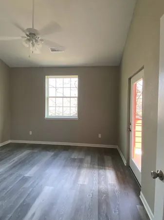 an empty room with wooden floor and windows