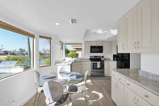 a large kitchen with a large window appliances and cabinets