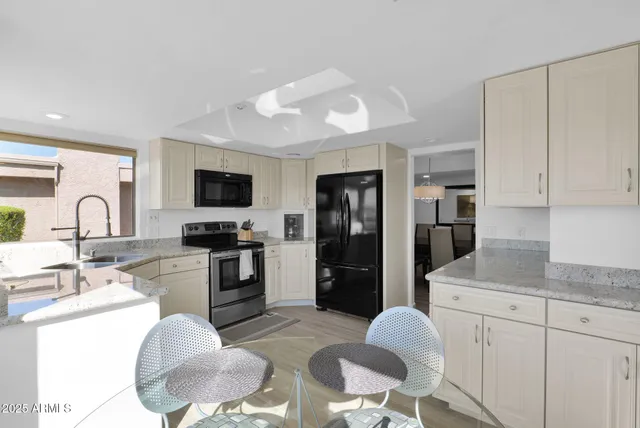 a kitchen with stainless steel appliances granite countertop a stove a sink and a refrigerator