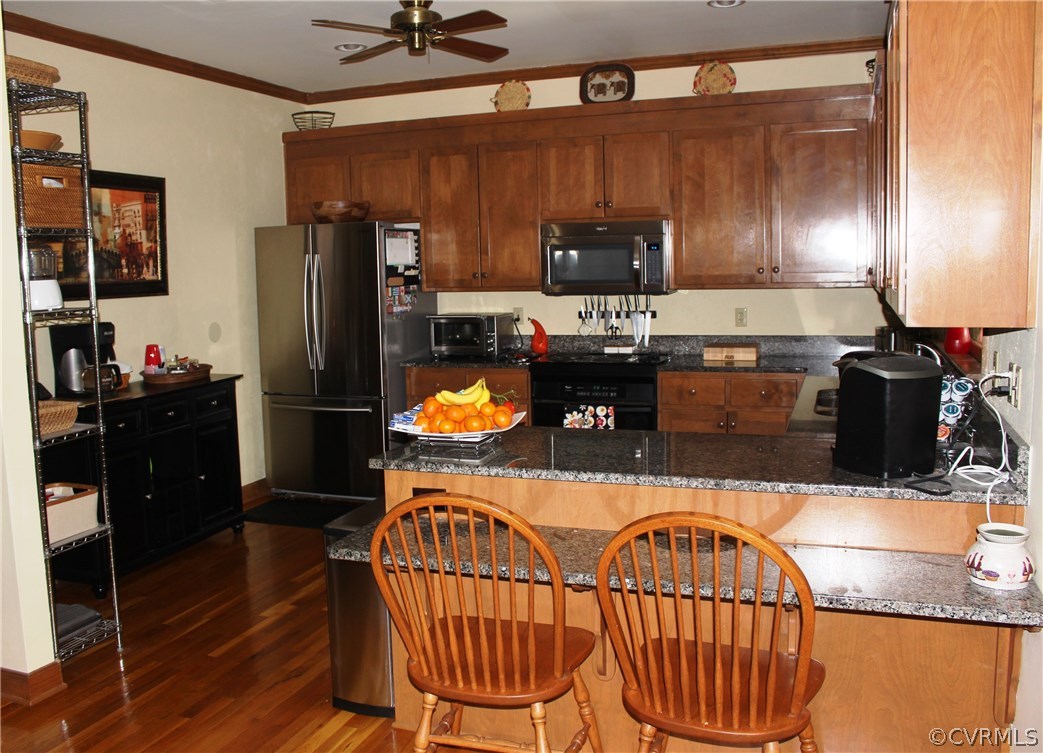 6501 Moseley Road Moseley, VA 23120 - Photo 8 of 27 a kitchen with stainless steel appliances kitchen island granite countertop a refrigerator a stove a sink and dishwasher with wooden floor