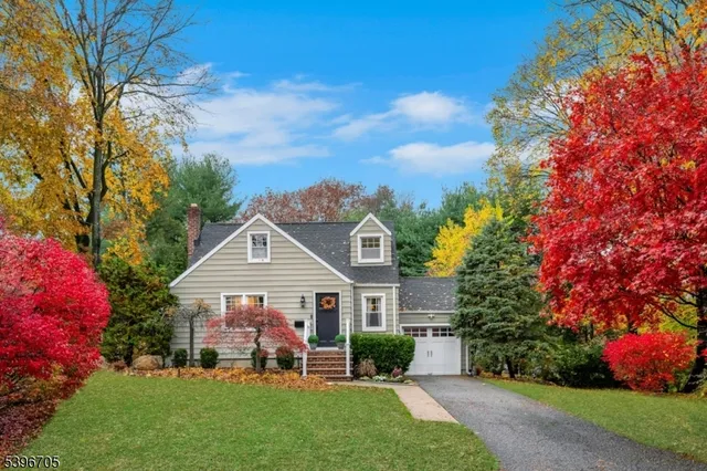 a front view of a house with a garden and trees